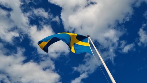Swedish Flag Waving Against Blue Sky