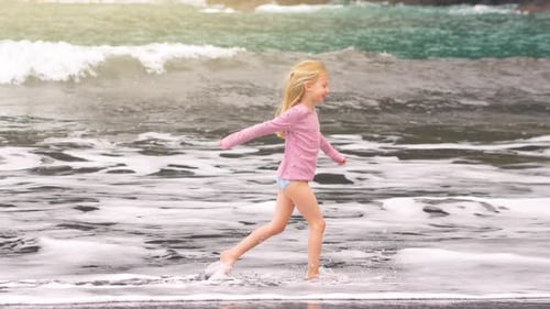 Joyful moments of a girl running through waves at the beach during summer
