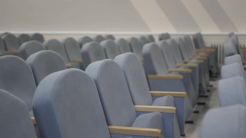 Soft Auditorium Seats with Wood Armrests in Empty Hall