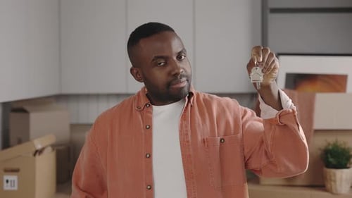 Close Up of Happy African American Man Holding Keys in Hands Showing to Camera