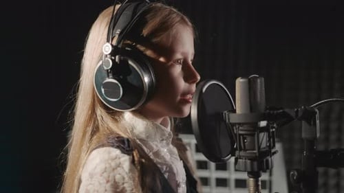 Girl in Headphones Sings in Recording Studio