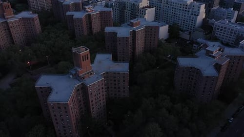 Aerial footage pans down to bring lonely ball court in the middle of housing projects into focus. i