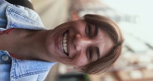 Mature latin woman smiling in front of camera in the city - Vertical video