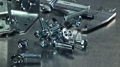 Shiny Metal Hardware Falling on Reflective Surface