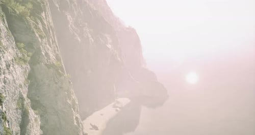 Scenic Coastal Cliffs Overlooking Tranquil Waters at Sunset Near a Serene Beach