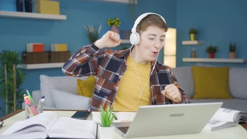 Young Adult Dancing to Music at Desk