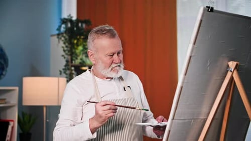Senior Man Painting on Canvas in Art Studio