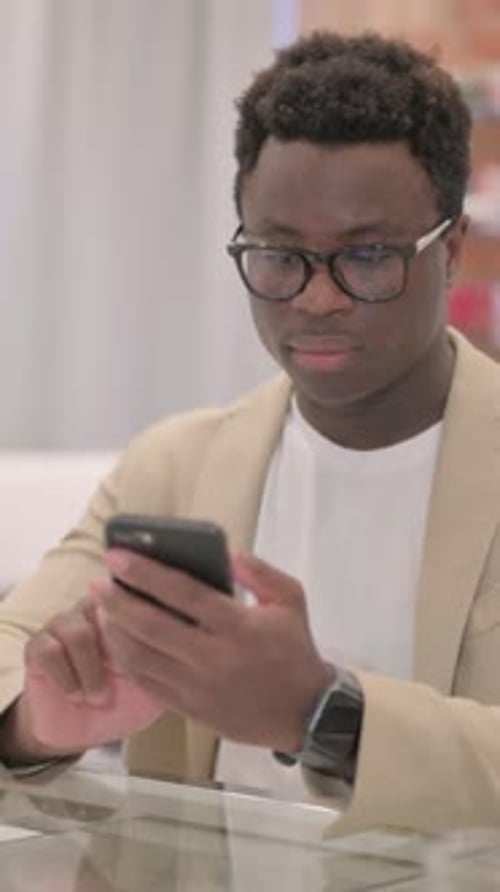 Man in Glasses Reacts to Phone in Store
