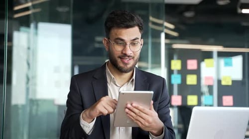 Young Man Using Tablet in Modern Office