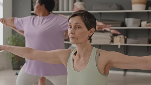 Senior Woman Practicing Yoga during Group Class