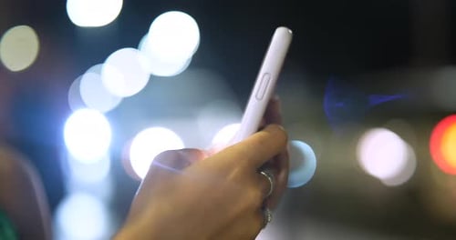 Close up of a young woman hands are using a smartphone phone to send messages, make calls in a cen