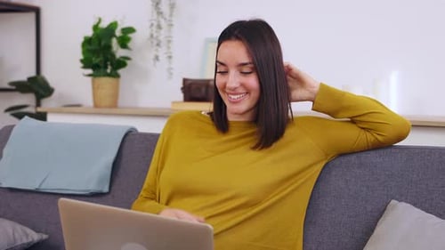 Young Woman Video Chatting on Laptop at Home