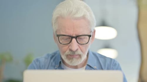 Close Up of Old Man Typing on Laptop in Office