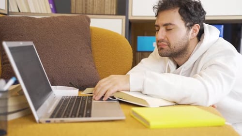 Tired Young Adult Studying At Home With Laptop