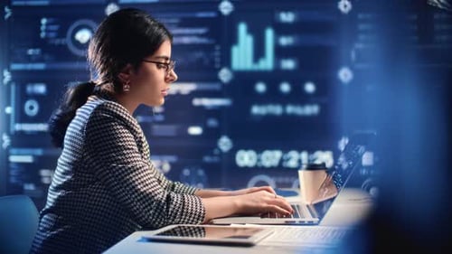 Woman Typing at Computer in Modern Office at Night