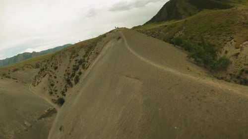Dirt Track and Resting Motorcyclist on Hill Ridge