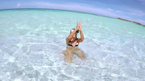 Tourist woman immersed in virtual reality beach experience in tropical bali water
