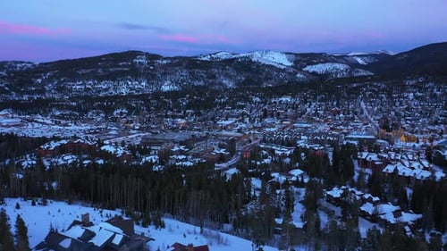 Suburban homes and rural farm fields in winter snow at colorful sunset. Aerial in USA. Modern reside
