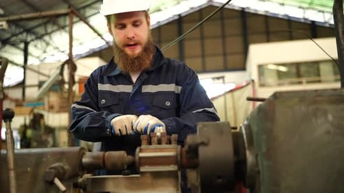 Fabrikarbeiter richtet CNC-Drehmaschine ein