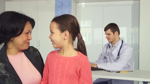 Joyful Woman and Her Daughter Share a Moment at the Children's Hospital