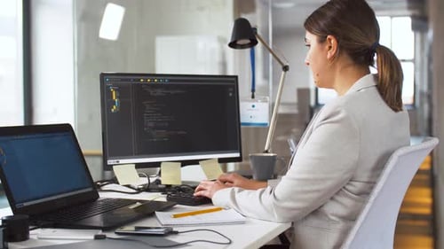 Woman Typing Code on Computer at Office Desk