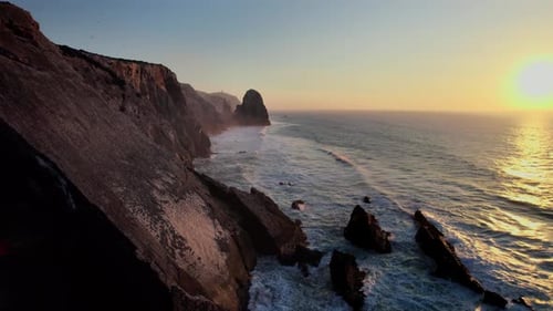Rolling waves on the west coast of Portugal during sunset.