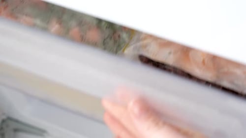 Cellophane bags with colorful frozen vegetables in freezer drawer top view.