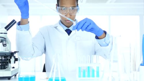 Scientist Working in Laboratory Pouring Chemical Solution in Test Tube