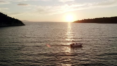 Aerial view on motor boat in waving sea at sunset in summer day