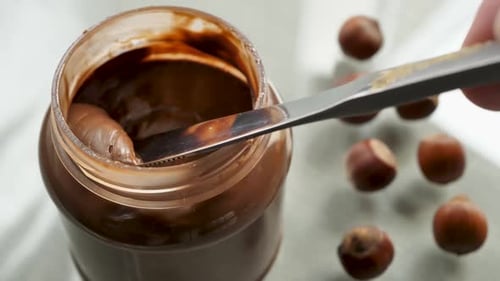 Using a Table Knife Take the Chocolate Nut Butter From the Jar and Spread It on the Bread Breakfast