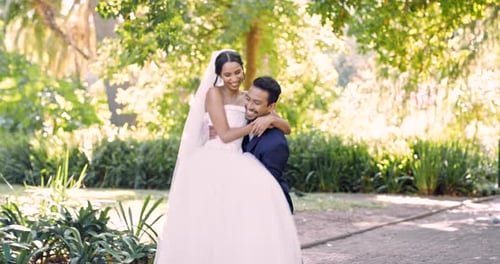 Love, wedding and husband carrying his wife outdoor in a garden on their marriage day celebration