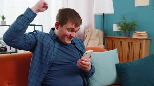 Man Celebrates Good News on Mobile Phone