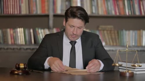 Male Lawyer Reading Legal Documents in Office