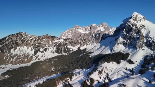 Winter Europe Switzerland mountain peak snow rocky cliff alpine landscape, aerial drone
