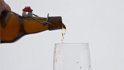 Beer pouring into glass from brown bottle