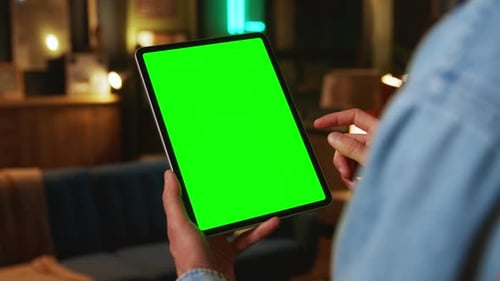 In the Evening Hands Holding Scrolling Tablet Computer with a Vertical Green Screen Mock Up