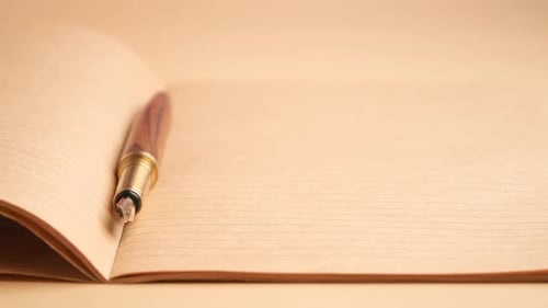 Writing Ideas in a Blank Notebook on a Desk