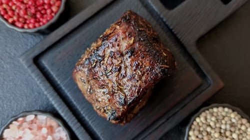Roasted Beef Loin on Dark Wood Board with Spices