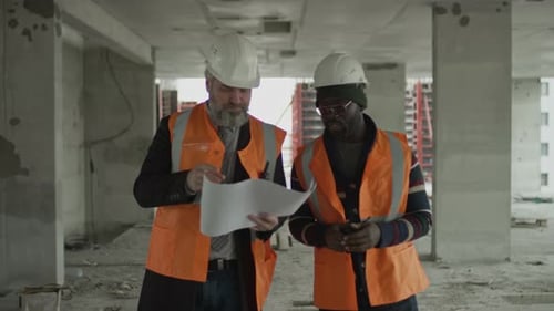 Construction Workers Discussing Blueprints on Building Site