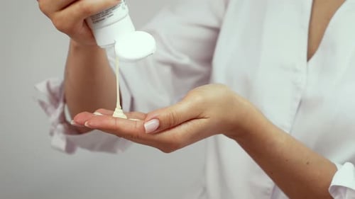 Dispensing Soothing Cream Into Hands During Skincare Session Spa Therapist Using Moisturizing