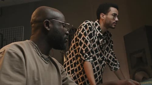 Young Singer and Producer Consulting at Work in Studio