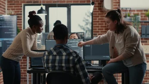 Mixed Software Development Team Discusses Source Code During Office Collaboration