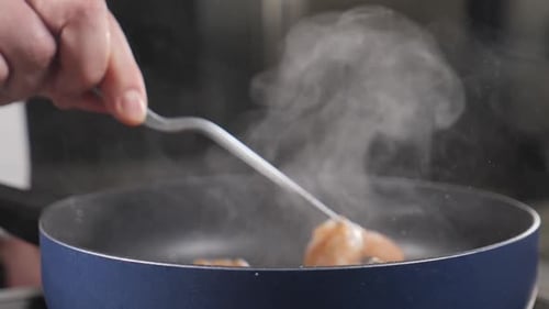 Flipping Shrimp in a Blue Skillet with Tongs