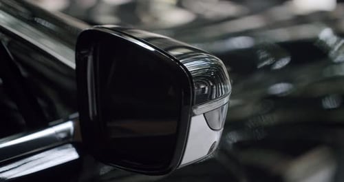 CloseUp View of a Car's Shiny Black Rearview Mirror