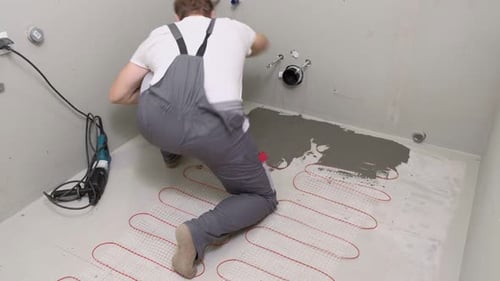 Construction Worker Preparing Tile Surface Mixing Mortar Substrate for Flooring Underfloor Heating