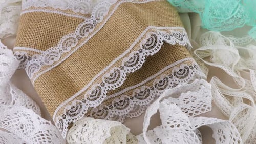 Laces of different textures and colors on a rotating display case. The theme of sewing accessories