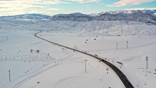Aerial View of Snow-Covered Mountain Road in Winter Landscape