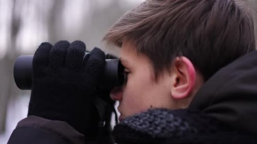 Side View Closeup Concentrated Teenage Boy Looking Away with Binoculars