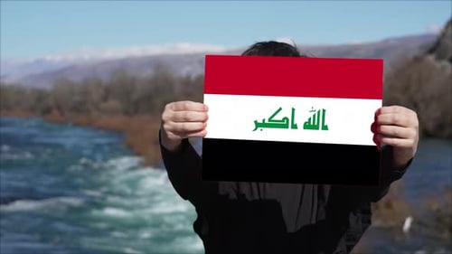 Person Holding Banner With Flag Of Iraq