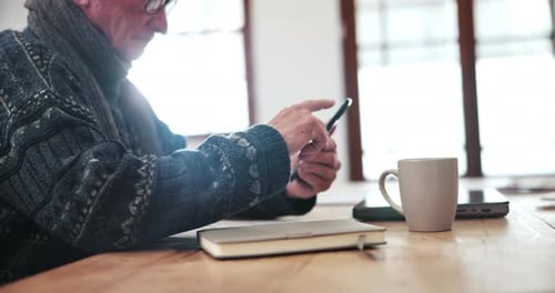 Senior Adult Using a Smartphone Indoors at Table